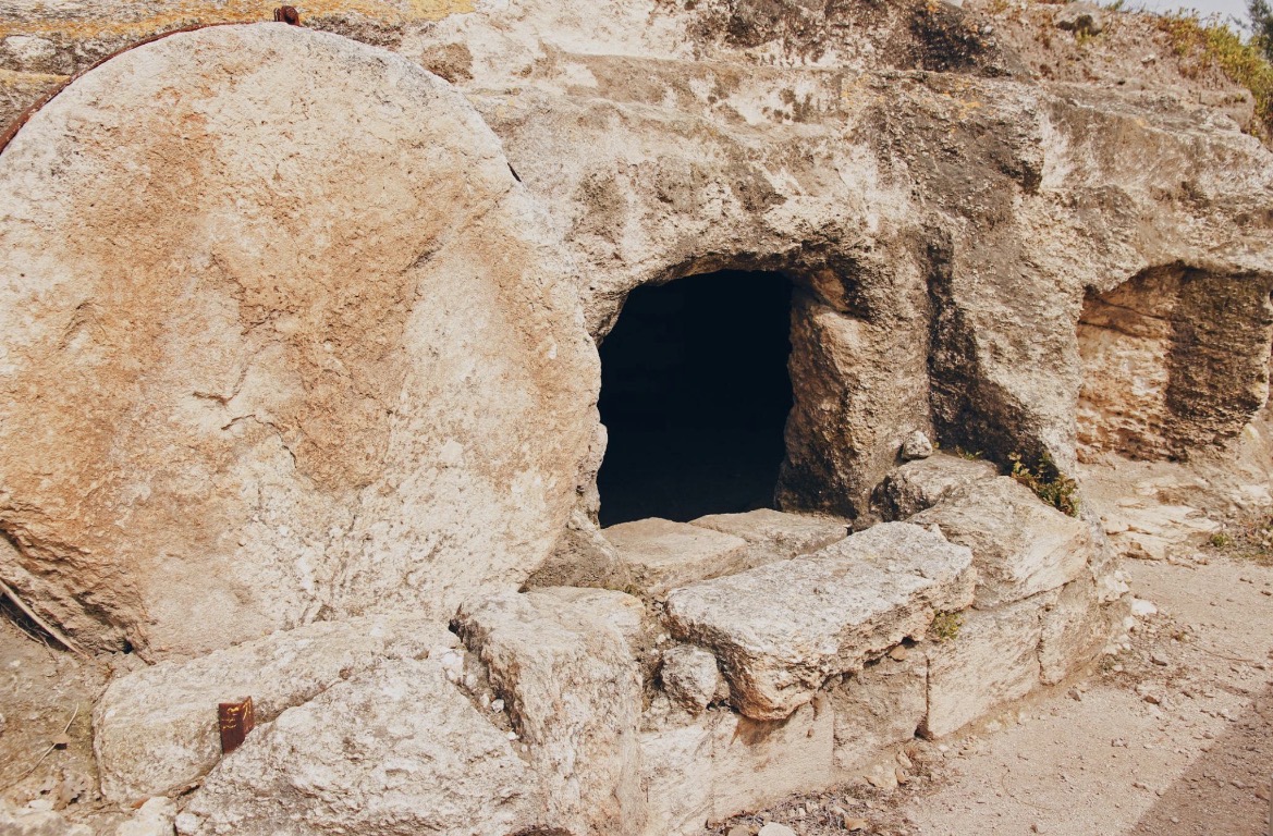 An empty rock-cut tomb with a large circular stone rolled aside